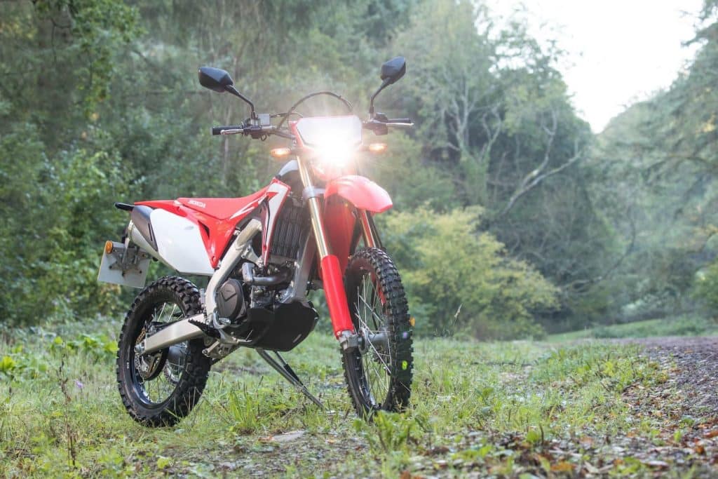 Honda CRF450L in field with light on