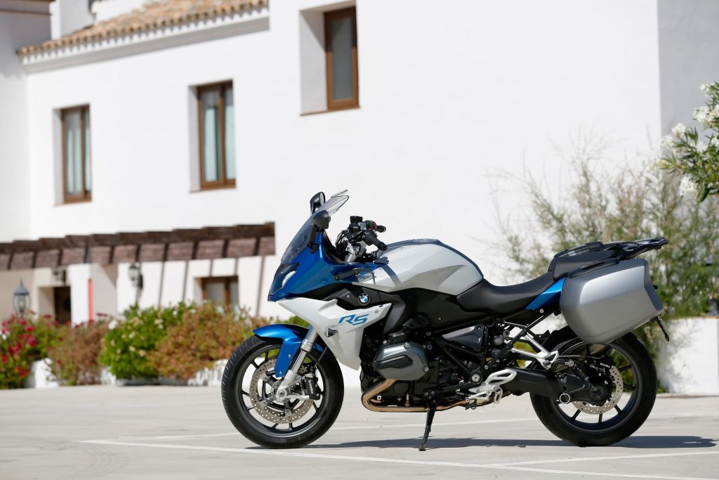 BMW R 1200 RS outdoors on kickstand by white building